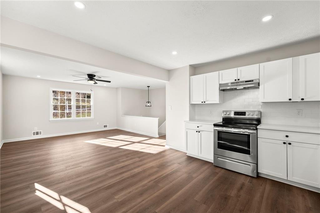 109 Tall Tree Road Athens, GA 30606 - Photo 11 of 33 a kitchen with granite countertop a stove cabinets and wooden floor
