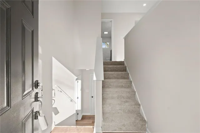 a view of a hallway with wooden floor and staircase