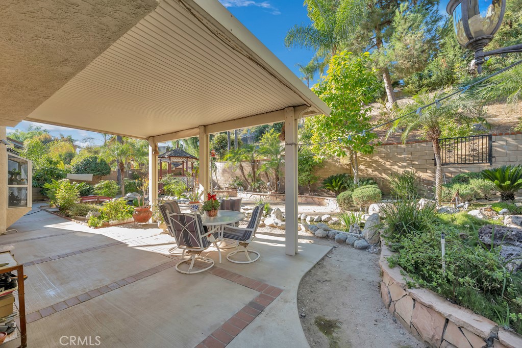 24338 Delta Drive Diamond Bar, CA 91765 - Photo 16 of 20 a view of a patio with a table chairs and a backyard