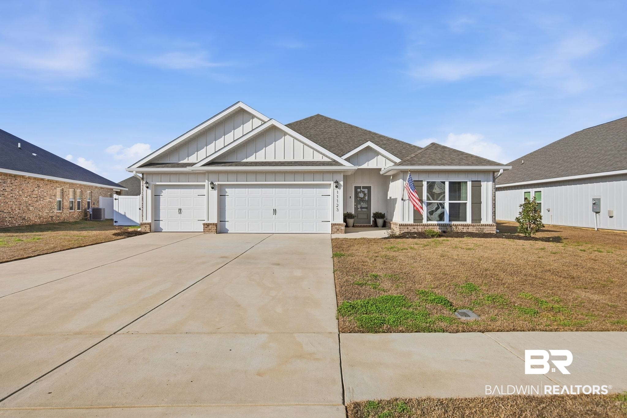 11123 Genuine Risk Circle Daphne, AL 36526 - Photo 5 of 67 View of front of property with board and batten siding, concrete driveway, an attached garage, a front lawn, and roof with shingles