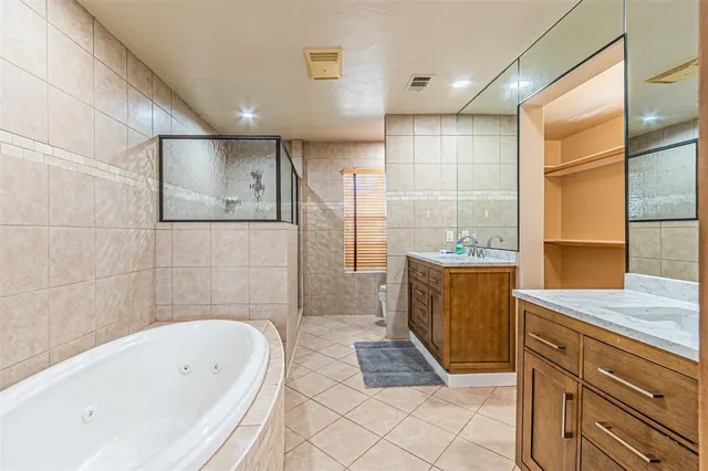 a bathroom with a granite countertop sink a toilet a mirror and shower