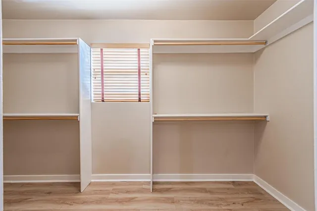 a view of walk in closet with empty racks