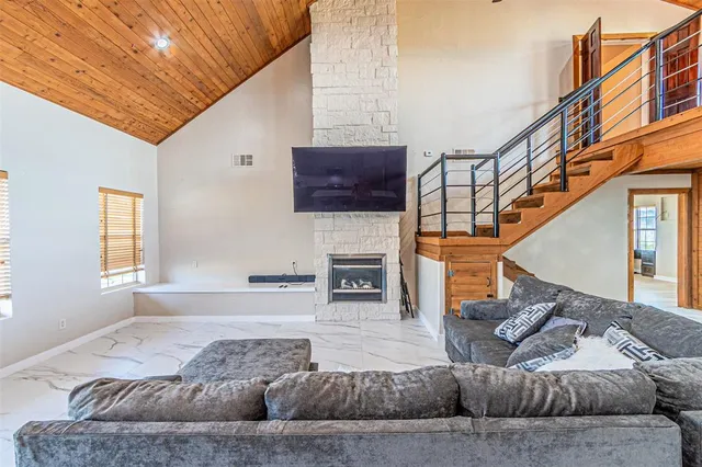 a living room with furniture a fireplace and a flat screen tv