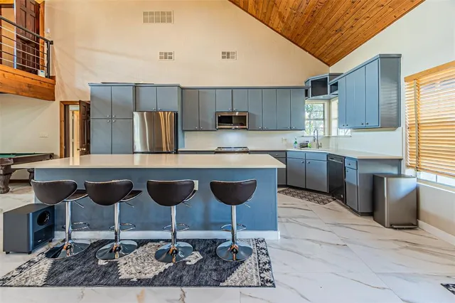 a kitchen with granite countertop a table chairs stove and cabinets