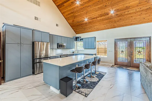a large kitchen with stainless steel appliances granite countertop a sink refrigerator and cabinets