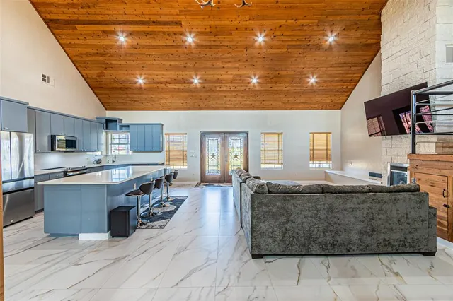 a living room with stainless steel appliances kitchen island granite countertop furniture and a kitchen view