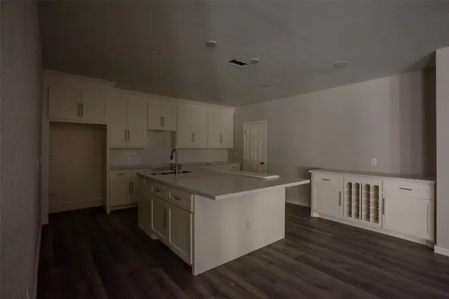 a kitchen with a stove and wooden floor