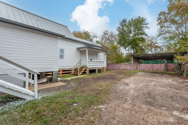 a view of a house with backyard and trees