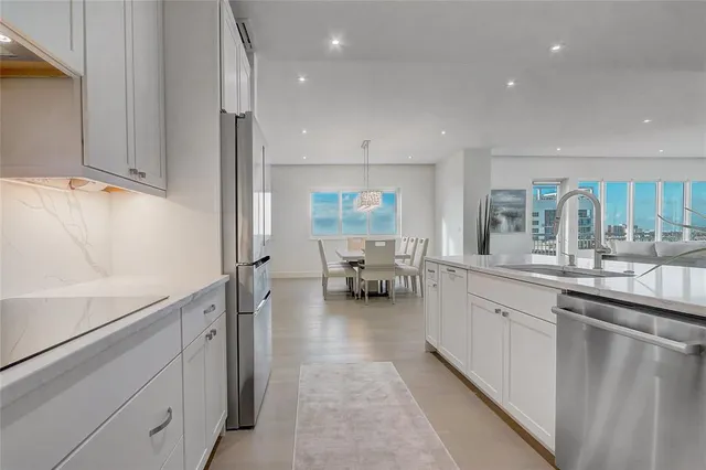 a kitchen with white cabinets and refrigerator