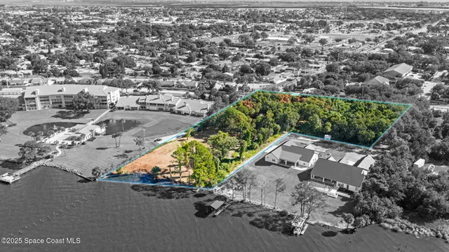 an aerial view of a house with a yard and lake view in back