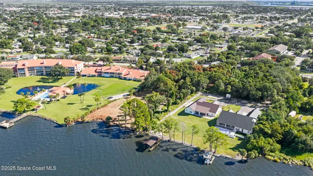 an aerial view of lake and residential houses with outdoor space