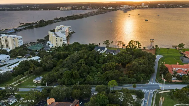 an aerial view of a house with lots of trees houses and lake view