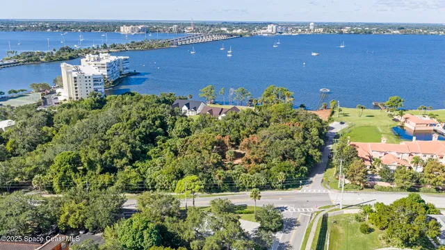 an aerial view of a house with a yard lake and ocean view