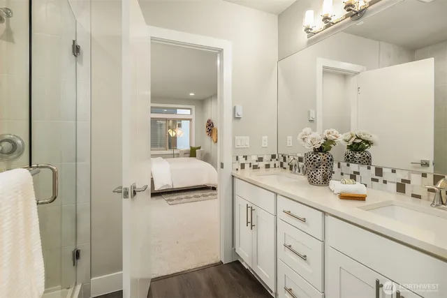 a bathroom with a double vanity sink mirror and shower