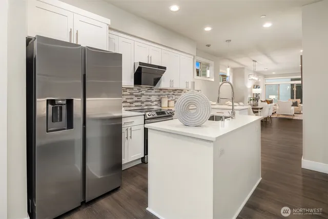 a kitchen with stainless steel appliances granite countertop a refrigerator and a stove top oven