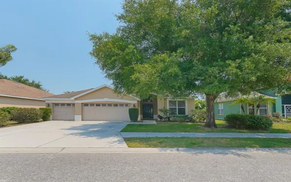 a front view of a house with a yard and trees