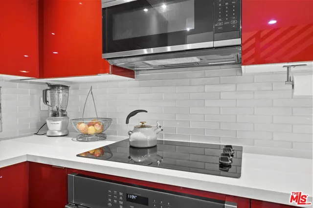 a kitchen with a sink a counter space appliances and cabinets