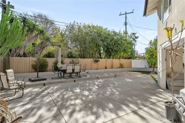 a view of backyard with a table and chairs and wooden fence