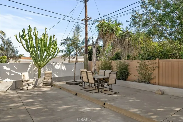 a view of a patio with table and chairs and a large tree