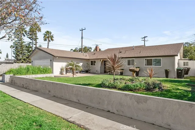 a front view of a house with a yard and potted plants