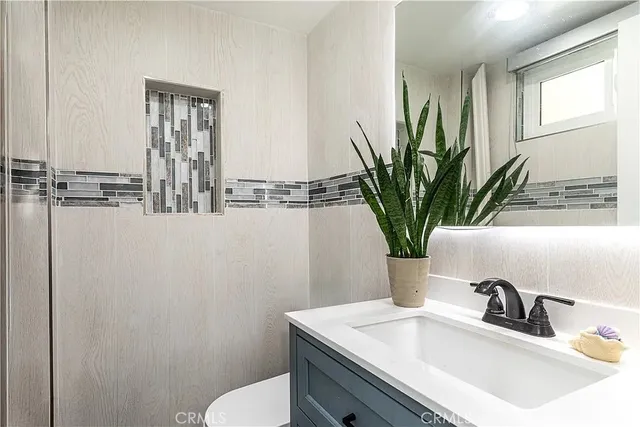 a bathroom with a granite countertop sink and a bathtub