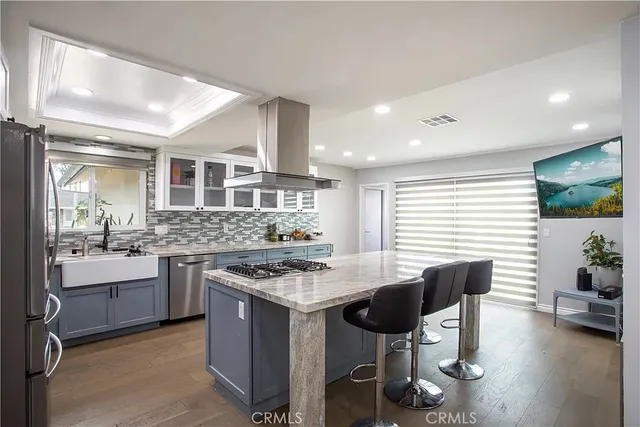 a kitchen with a table chairs stove and wooden floor