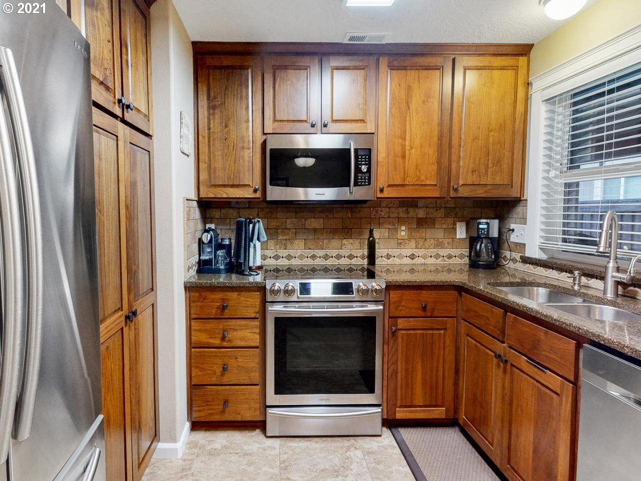 1324 S Street Springfield, OR 97477 - Photo 22 of 32 a kitchen with stainless steel appliances granite countertop a stove a sink and a microwave