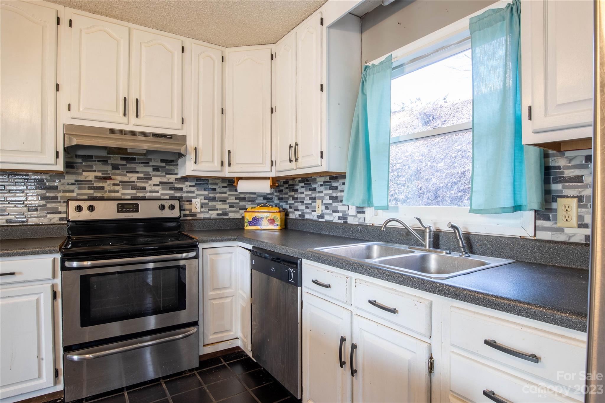 3954 Highway 80 Bakersville, NC 28705 - Photo 14 of 34 a kitchen with granite countertop a sink stainless steel appliances and white cabinets
