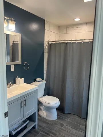 a bathroom with a sink a toilet a mirror and shower