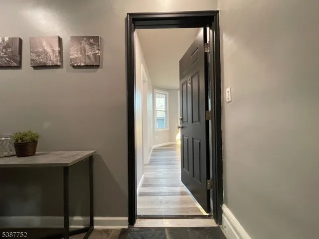 a view of a hallway with wooden floor and closet