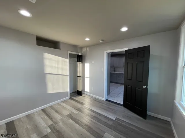 a view of empty room with wooden floor and window