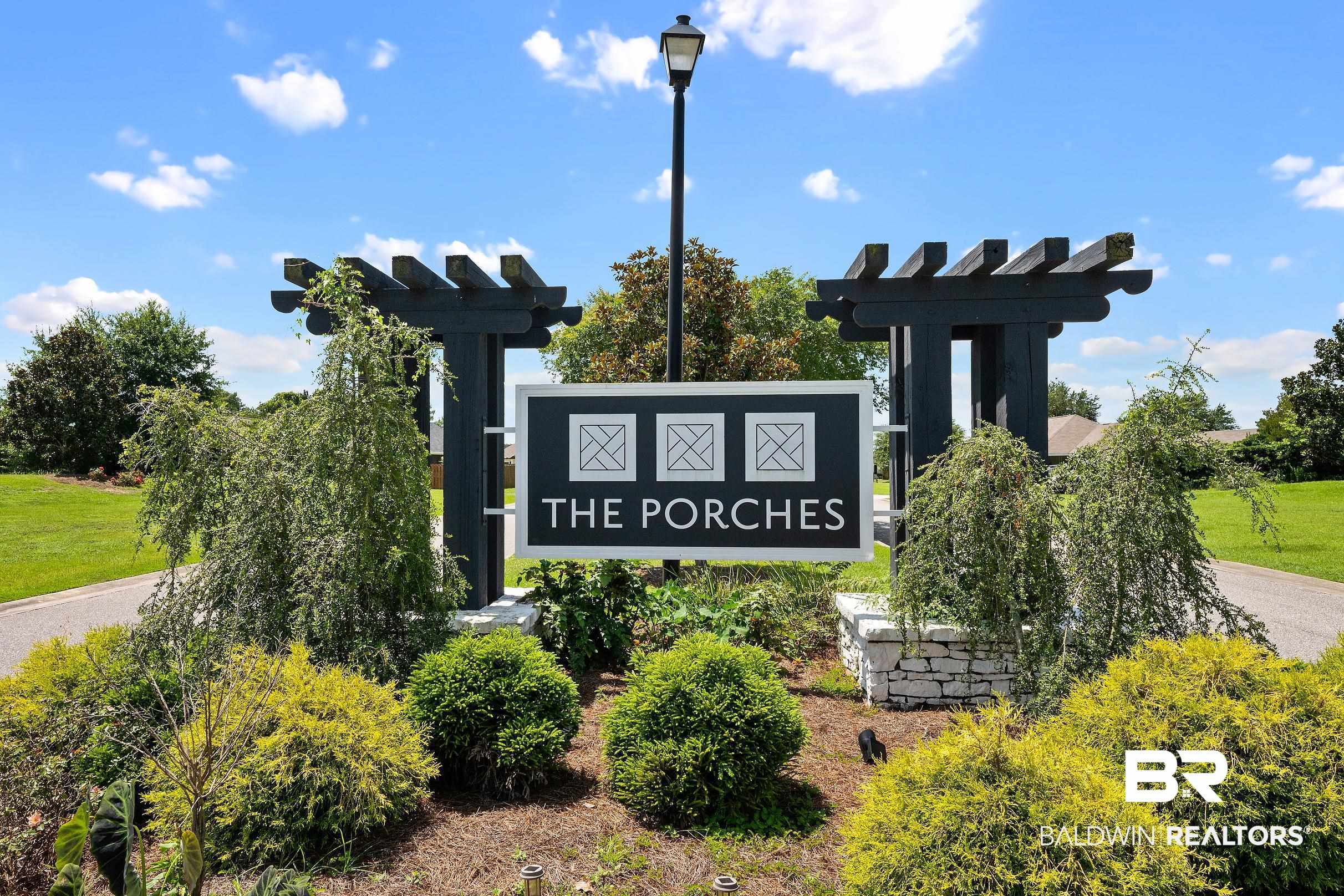 23997 Veranda Circle Elberta, AL 36530 - Photo 27 of 28 Community entrance sign featuring dark-stained wood pergola accents, a stone base, and varied landscaping