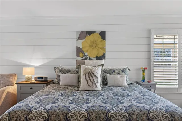 a living room with stainless steel appliances lots of furniture and wooden floor