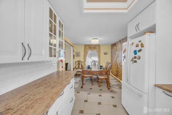 a living room with furniture and a refrigerator