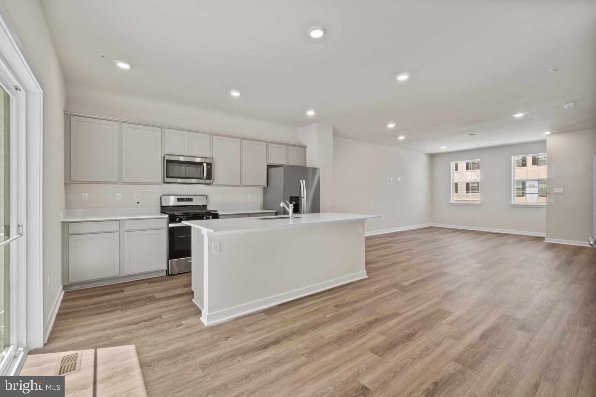 7510 Fern Gully Way Brandywine, MD 20613 - Photo 5 of 31 a kitchen with wooden floors white cabinets appliances and sink