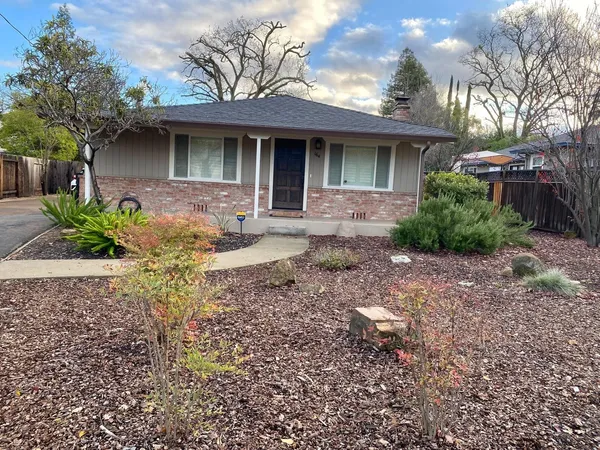 a front view of a house with a yard and potted plants