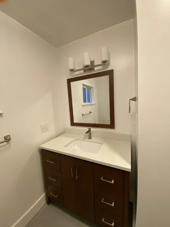 a bathroom with a sink vanity and mirror