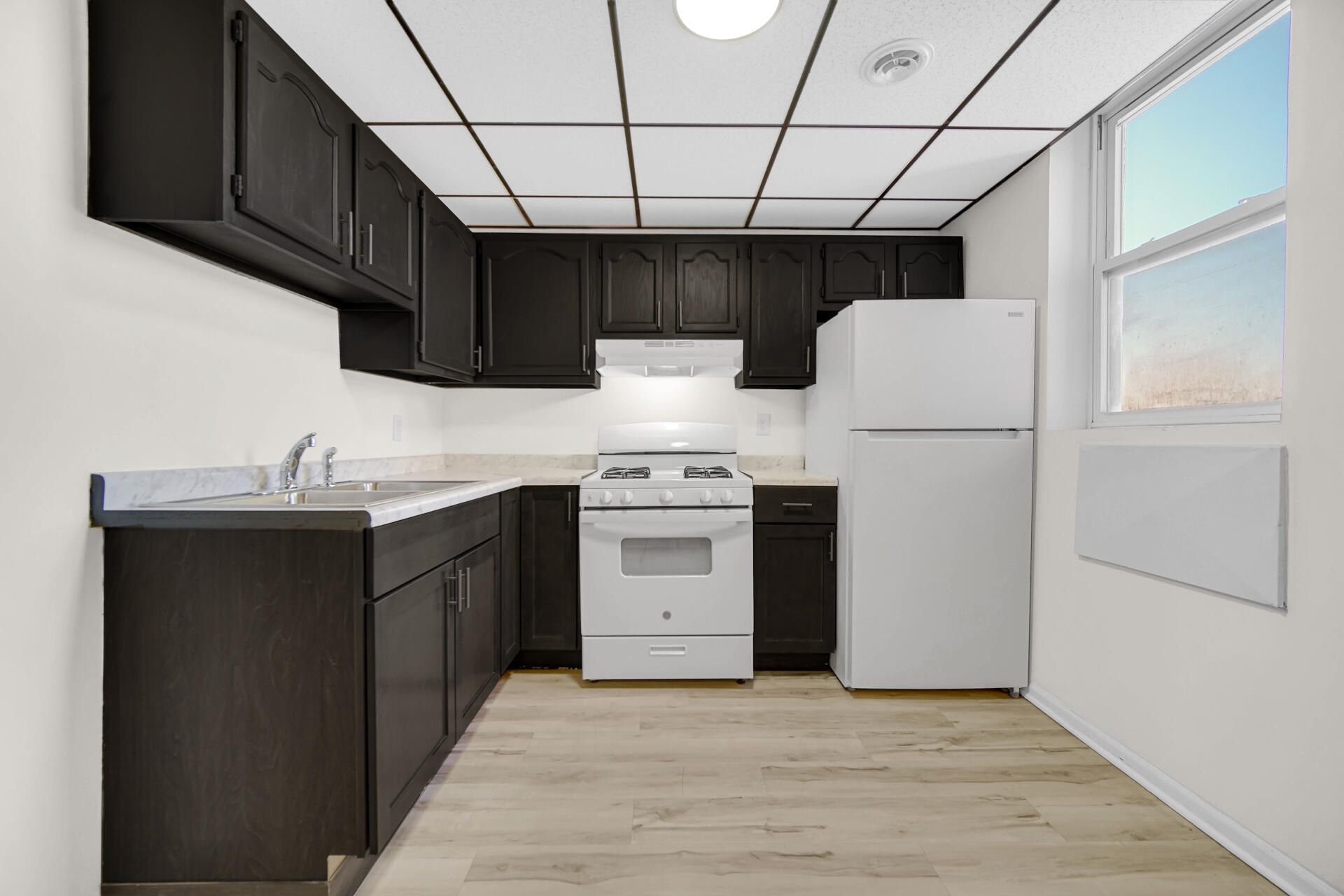 3501 Fir Street East Chicago, IN 46312 - Photo 12 of 26 a kitchen with a sink dishwasher a white stove refrigerator and cabinets