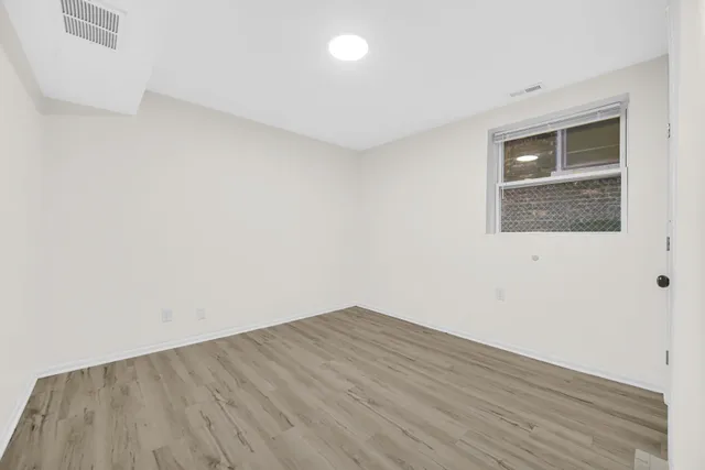 a view of an empty room with wooden floor