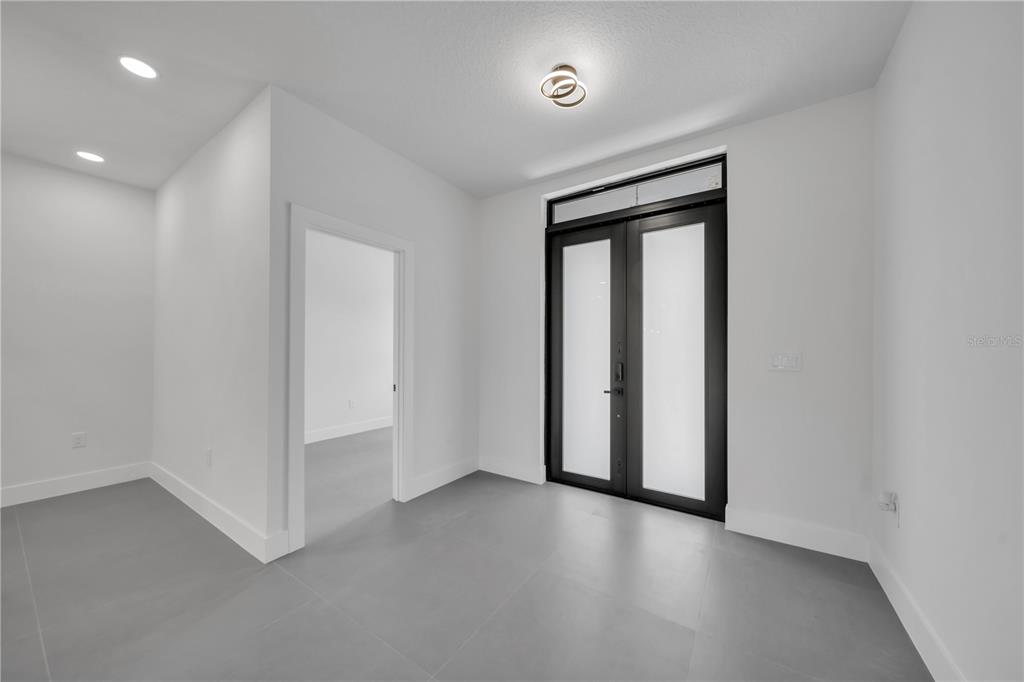 2328 Irondale Road North Port, FL 34287 - Photo 6 of 45 an empty room with wooden floor and sliding door