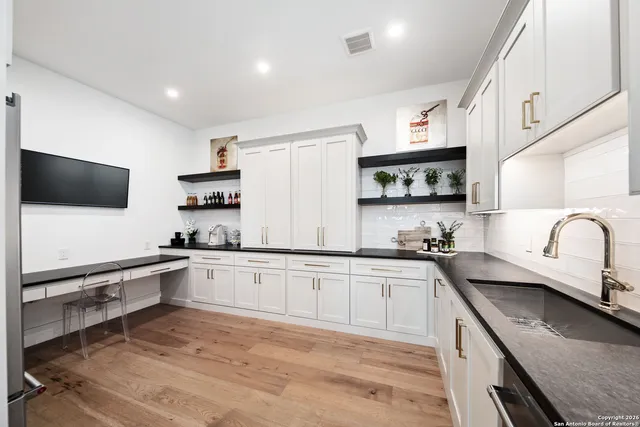 a kitchen with stainless steel appliances granite countertop a sink a stove top oven a counter space and cabinets