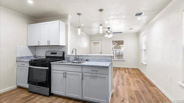 a kitchen with a sink stove and cabinets