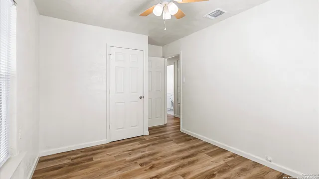 a view of an empty room with wooden floor