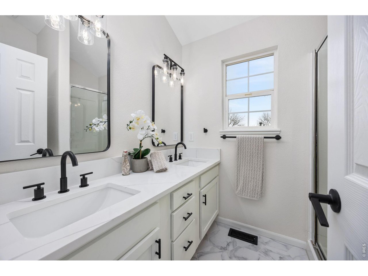 4927 30th Street Greeley, CO 80634 - Photo 18 of 35 a bathroom with double vanity sink a mirror and a shower