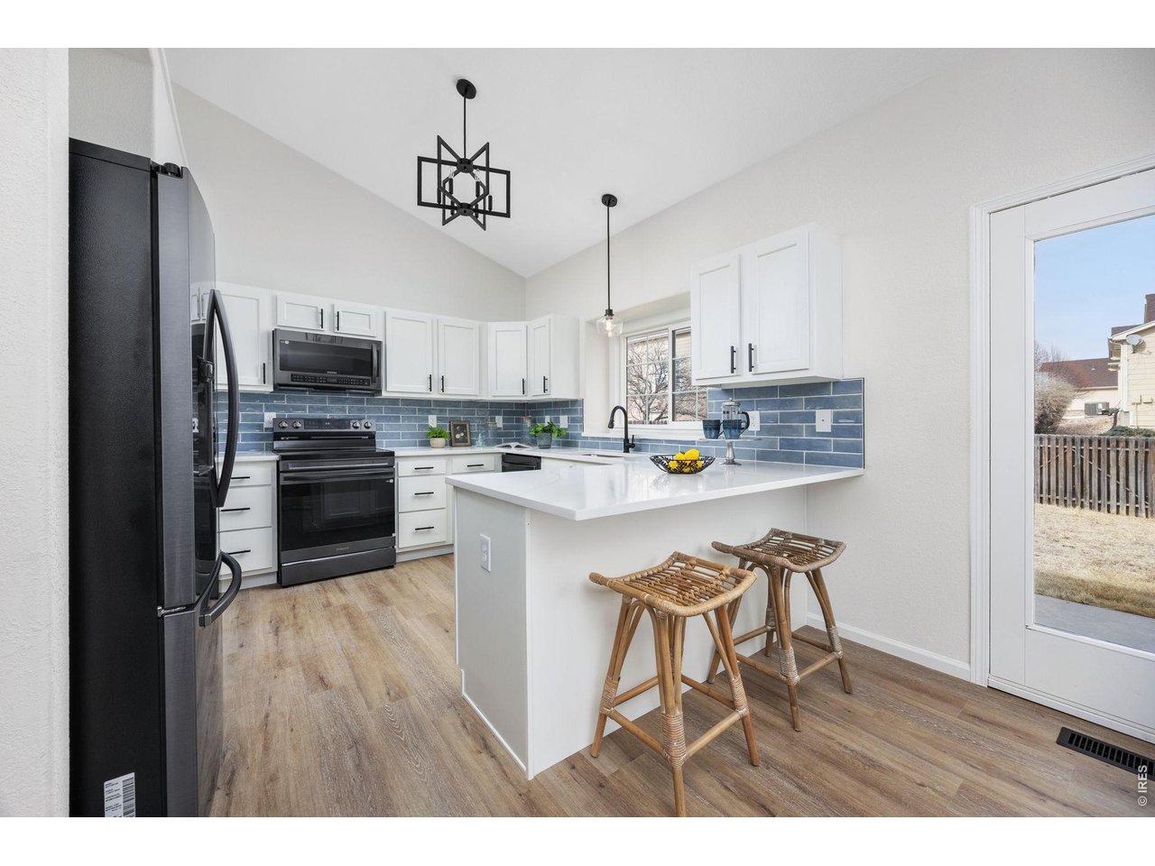 4927 30th Street Greeley, CO 80634 - Photo 6 of 35 a kitchen with kitchen island white cabinets stainless steel appliances and sink