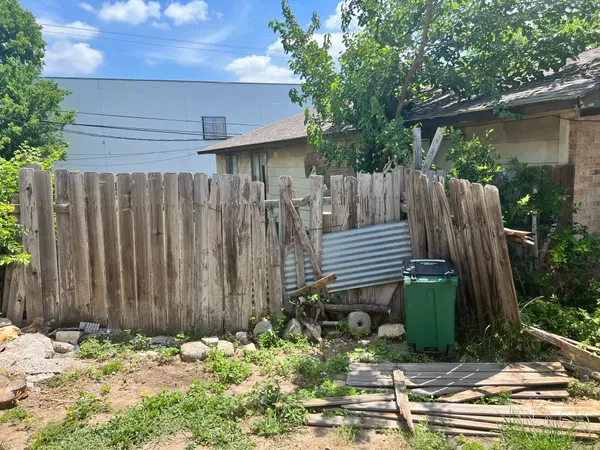 a view of a backyard with wooden fence and a bench
