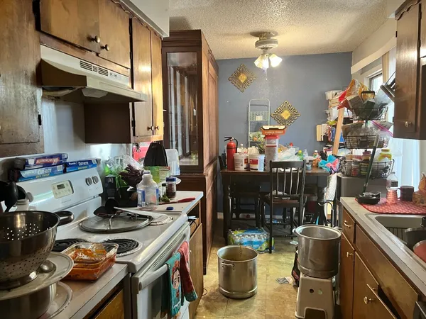 a kitchen with a stove and a wooden floor