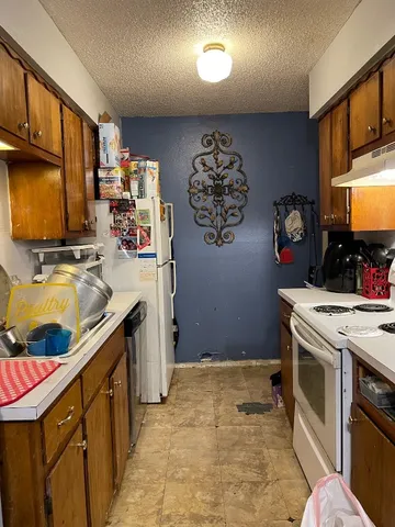 a kitchen with a refrigerator and a stove top oven