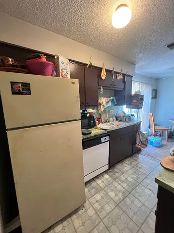 a kitchen with a refrigerator and a stove top oven