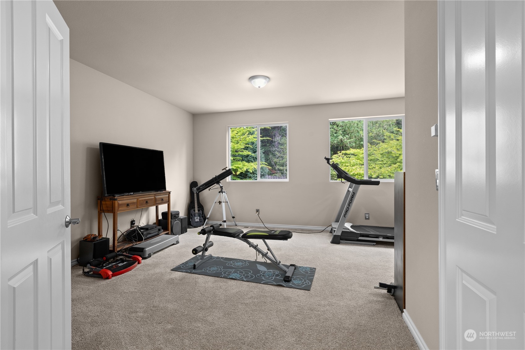27746 Maple Ridge Way Southeast Maple Valley, WA 98038 - Photo 21 of 37 a living room with furniture gym equipment and a flat screen tv